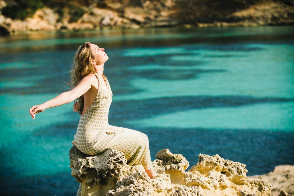 Schmuckbild: Junge Frau sitzt am See